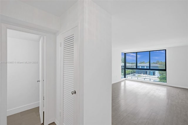 9800 W Bay Harbor Dr Unit 401, Bay Harbor Islands, FL 33154 - hallway featuring wood finished floors, a wall of windows, and baseboards