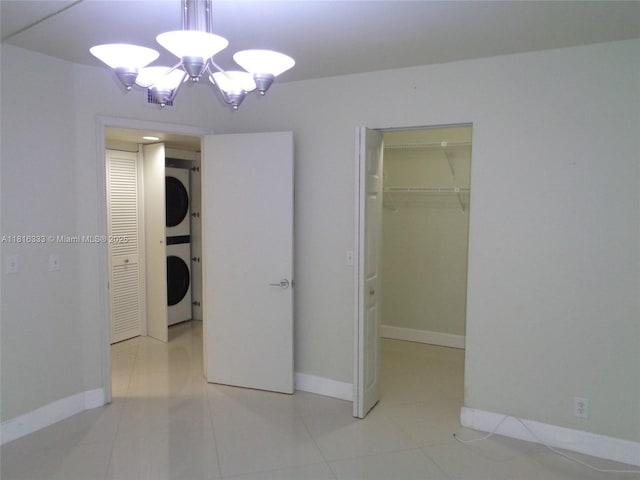 900 SW 125th Way Unit 112R, Pembroke Pines, FL 33027 - unfurnished bedroom featuring stacked washer and clothes dryer, a chandelier, and baseboards