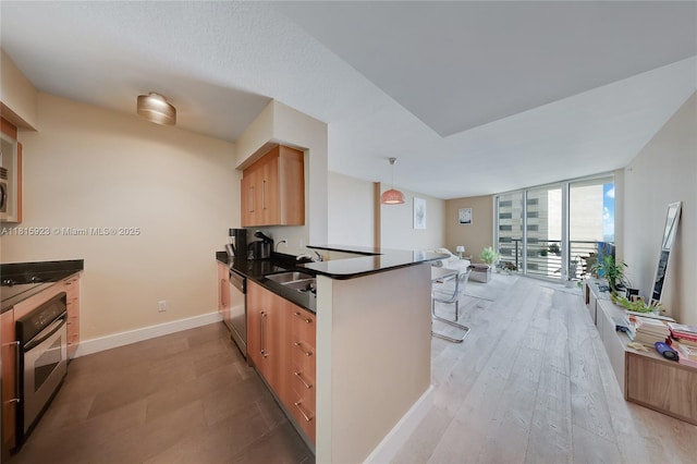 335 S Biscayne Blvd Unit 3110, Miami, FL 33131 - kitchen featuring stainless steel appliances, dark countertops, a peninsula, expansive windows, and light wood-style floors