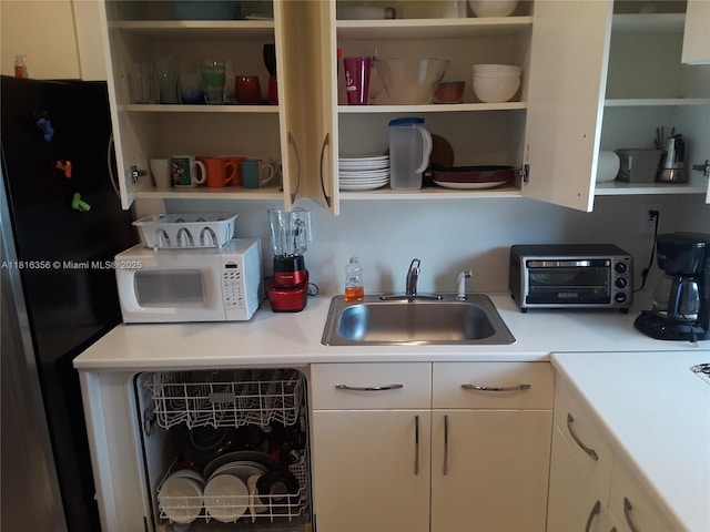250 180th Dr Unit 159, Sunny Isles Beach, FL 33160 - kitchen with open shelves, freestanding refrigerator, a sink, white microwave, and light countertops