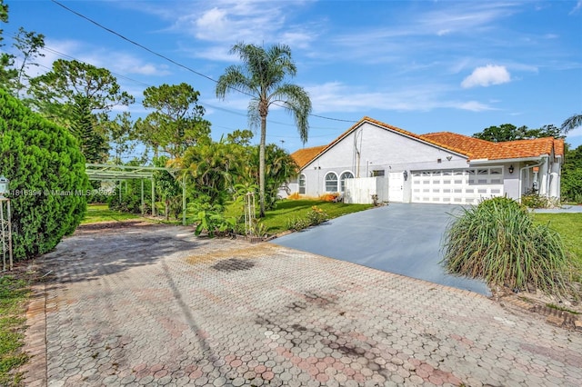 17084 N 33rd Rd N, Loxahatchee, FL 33470 - view of front facade with decorative driveway, an attached garage, stucco siding, a tiled roof, and a front yard
