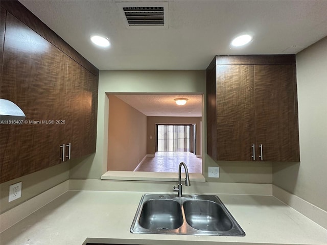 2541 NW 56th Ave Unit 3-19, Lauderhill, FL 33313 - kitchen featuring light countertops, a sink, dark brown cabinets, and recessed lighting