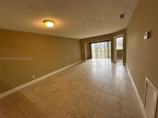 2541 NW 56th Ave Unit 3-19, Lauderhill, FL 33313 - unfurnished room with a textured ceiling, light tile patterned flooring, and baseboards