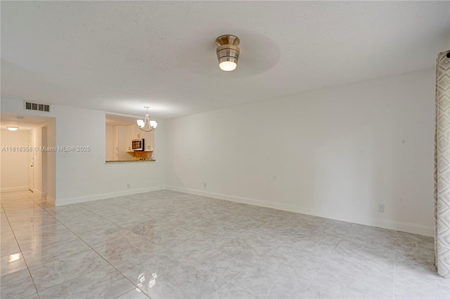 136 S Cypress Rd Unit 323, Pompano Beach, FL 33060 - unfurnished room with a chandelier and baseboards