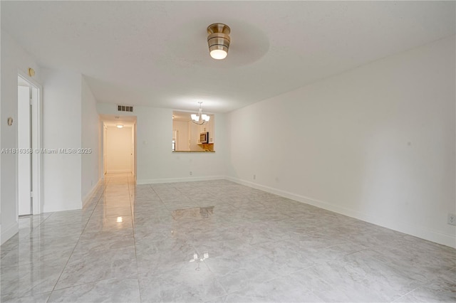 136 S Cypress Rd Unit 323, Pompano Beach, FL 33060 - spare room featuring a chandelier, light marble finish floors, baseboards, and ceiling fan