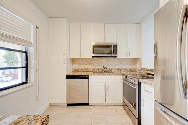 136 S Cypress Rd Unit 323, Pompano Beach, FL 33060 - kitchen with stainless steel appliances, a sink, light stone countertops, and decorative backsplash
