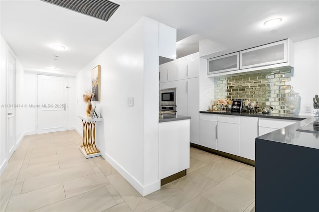 1800 S Ocean Dr Unit 2208, Hallandale Beach, FL 33009 - kitchen with dark countertops, decorative backsplash, glass insert cabinets, white cabinets, and stainless steel appliances