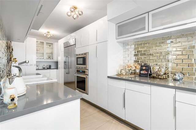 1800 S Ocean Dr Unit 2208, Hallandale Beach, FL 33009 - kitchen featuring built in appliances, stainless steel counters, backsplash, and glass insert cabinets