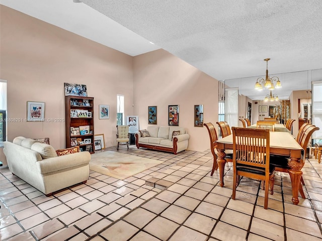 3121 N 52nd Ave, Hollywood, FL 33021 - dining space featuring a chandelier, plenty of natural light, a textured ceiling, a high ceiling, and light tile patterned flooring