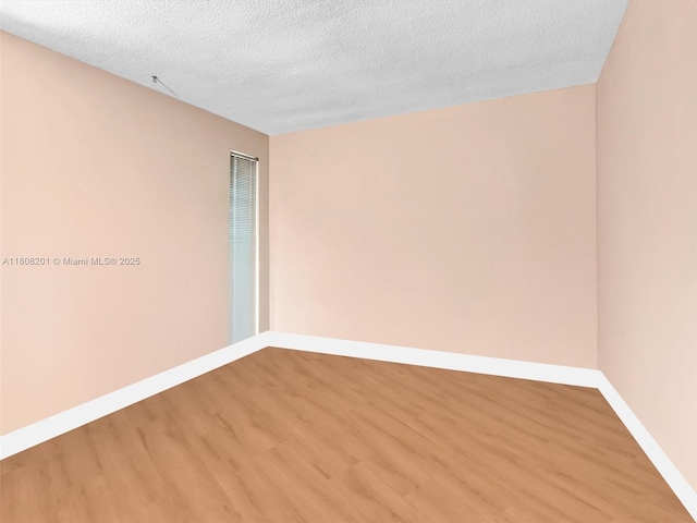 3121 N 52nd Ave, Hollywood, FL 33021 - unfurnished room with light wood-style flooring, baseboards, and a textured ceiling