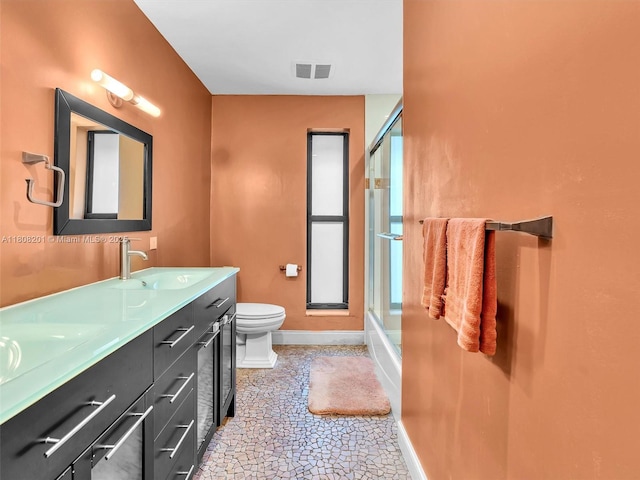 3121 N 52nd Ave, Hollywood, FL 33021 - full bathroom with baseboards, toilet, double vanity, stone finish floors, and combined bath / shower with glass door