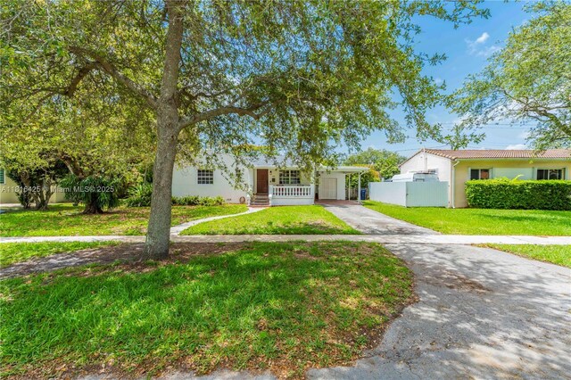 1110 Falcon Ave, Miami Springs, FL 33166 - single story home featuring concrete driveway, stucco siding, an attached carport, and covered porch