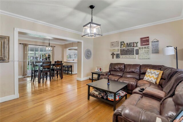 1110 Falcon Ave, Miami Springs, FL 33166 - living room with a chandelier, light wood-style floors, baseboards, and crown molding