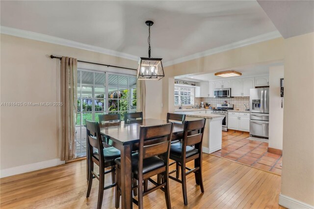 1110 Falcon Ave, Miami Springs, FL 33166 - dining space featuring crown molding, a chandelier, baseboards, and light wood-type flooring