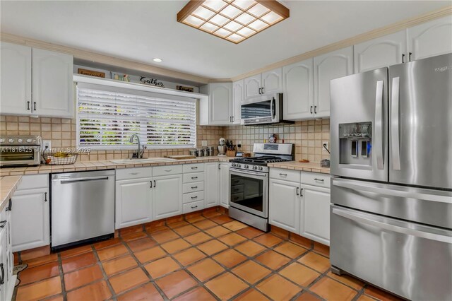 1110 Falcon Ave, Miami Springs, FL 33166 - kitchen with stainless steel appliances, tile countertops, white cabinets, and recessed lighting