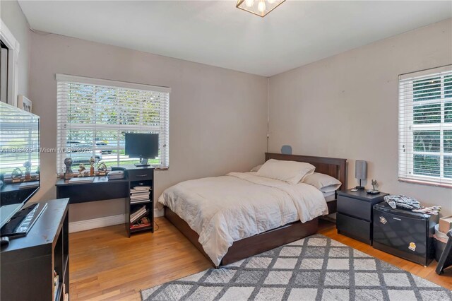 1110 Falcon Ave, Miami Springs, FL 33166 - bedroom featuring light wood finished floors, multiple windows, and baseboards