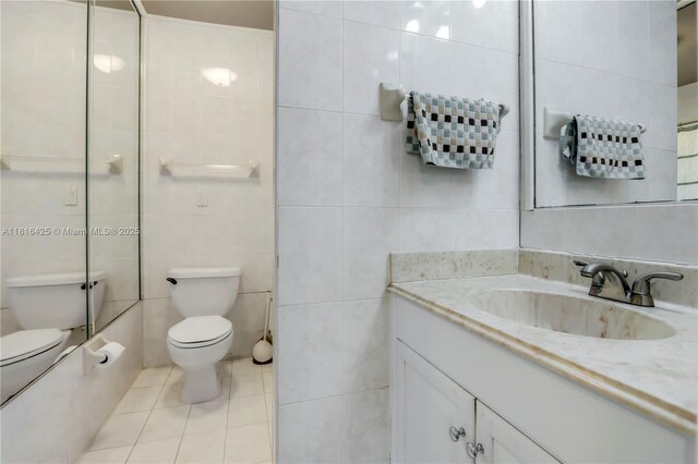 1110 Falcon Ave, Miami Springs, FL 33166 - bathroom featuring tile walls, toilet, vanity, and tile patterned floors