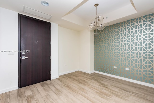 999 1st Ave Unit 2707, Miami, FL 33130 - spare room featuring a raised ceiling, light wood-style floors, baseboards, and a chandelier