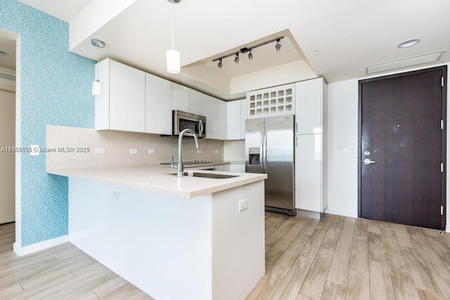 999 1st Ave Unit 2707, Miami, FL 33130 - kitchen with stainless steel appliances, track lighting, a peninsula, light wood finished floors, and light countertops