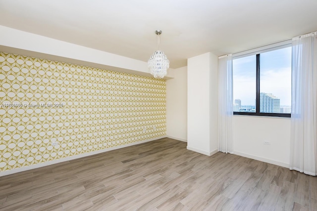 999 1st Ave Unit 2707, Miami, FL 33130 - spare room with a chandelier, baseboards, wood finished floors, and wallpapered walls