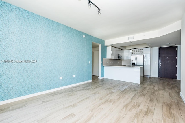 999 1st Ave Unit 2707, Miami, FL 33130 - unfurnished living room with light wood-style floors, baseboards, an accent wall, and wallpapered walls