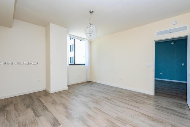 999 1st Ave Unit 2707, Miami, FL 33130 - unfurnished room featuring a chandelier, wood finished floors, and baseboards
