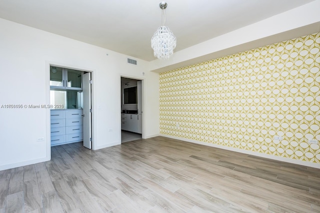 999 1st Ave Unit 2707, Miami, FL 33130 - unfurnished room featuring a chandelier, wallpapered walls, baseboards, and light wood-style floors