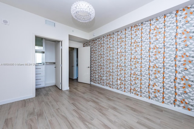 999 1st Ave Unit 2707, Miami, FL 33130 - unfurnished bedroom featuring a chandelier, wallpapered walls, wood finished floors, and baseboards