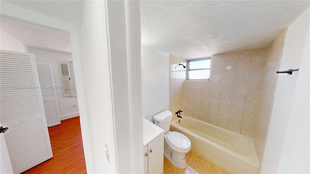 677 SW 9th Ave Unit 309, Miami, FL 33130 - bathroom featuring vanity, toilet, tub / shower combination, a textured ceiling, and wood finished floors