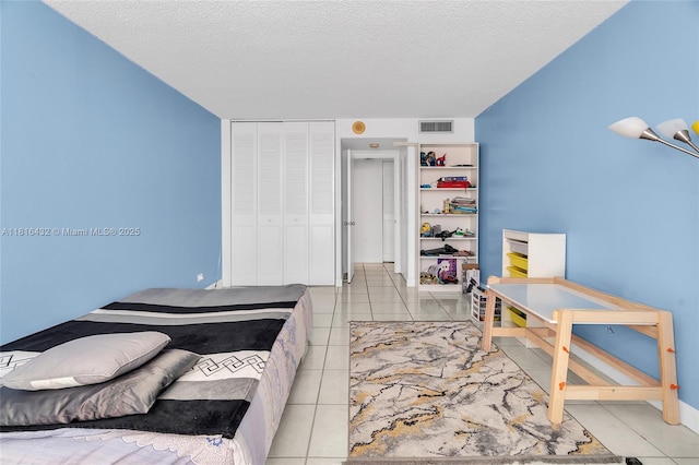 251 174th St Unit 2115, Sunny Isles Beach, FL 33160 - bedroom with light tile patterned floors, a textured ceiling, and a closet