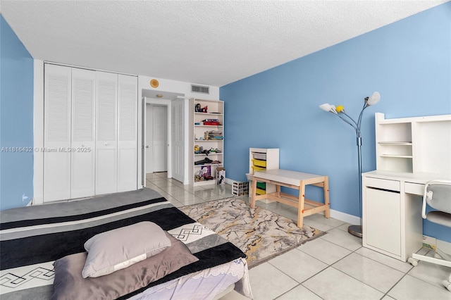 251 174th St Unit 2115, Sunny Isles Beach, FL 33160 - bedroom featuring light tile patterned floors, baseboards, a closet, and a textured ceiling