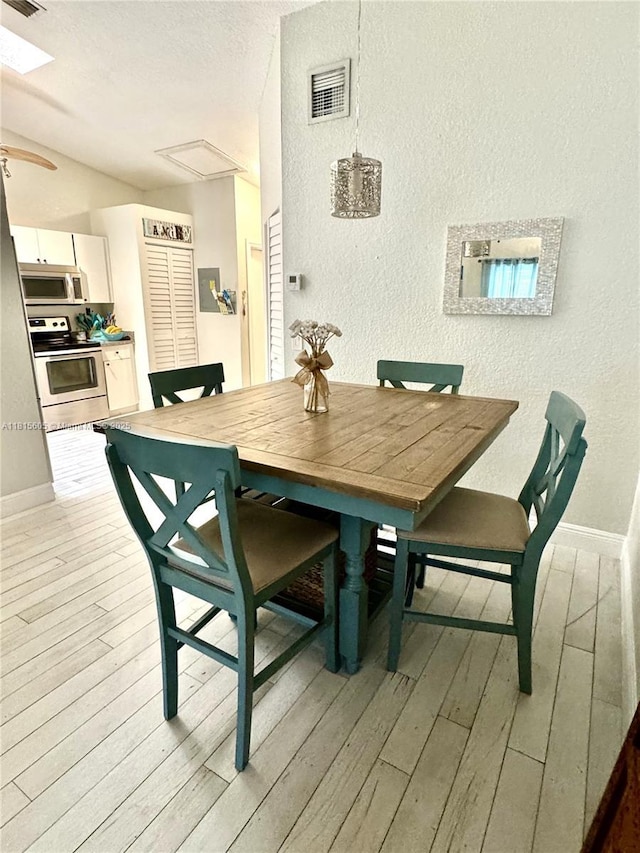 729 NW 47th St, Deerfield Beach, FL 33064 - dining space with wood-type flooring, baseboards, a textured wall, vaulted ceiling, and ceiling fan