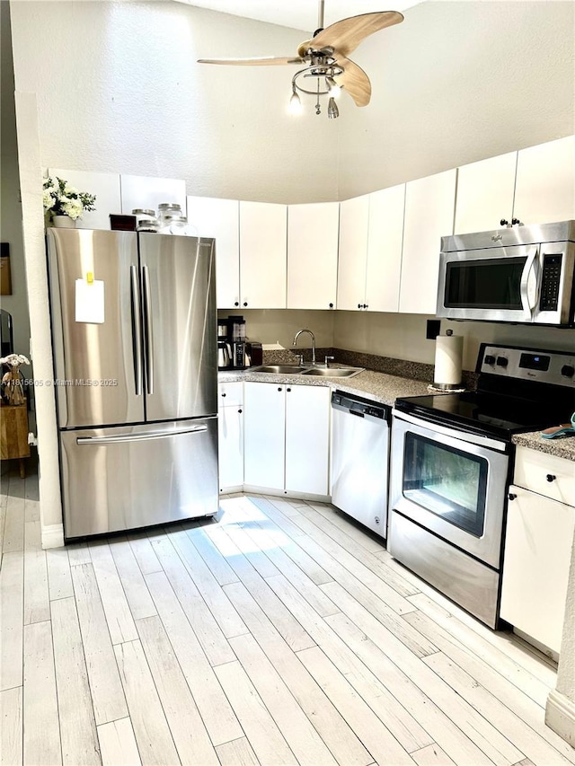 729 NW 47th St, Deerfield Beach, FL 33064 - kitchen featuring appliances with stainless steel finishes, light wood-style floors, and white cabinetry