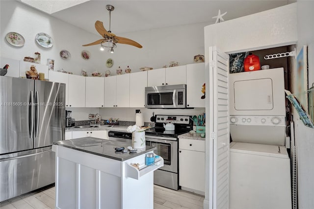 729 NW 47th St, Deerfield Beach, FL 33064 - kitchen with appliances with stainless steel finishes, stacked washing machine and dryer, a sink, ceiling fan, and light wood-type flooring