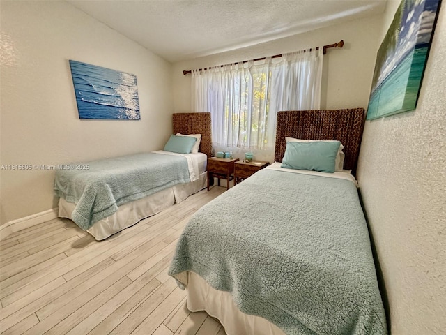 729 NW 47th St, Deerfield Beach, FL 33064 - bedroom featuring wood finished floors, vaulted ceiling, a textured wall, a textured ceiling, and baseboards