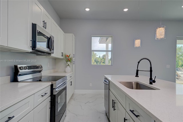 3121 71st St W, Lehigh Acres, FL 33971 - kitchen with stainless steel appliances, a sink, baseboards, light marble finish flooring, and decorative light fixtures