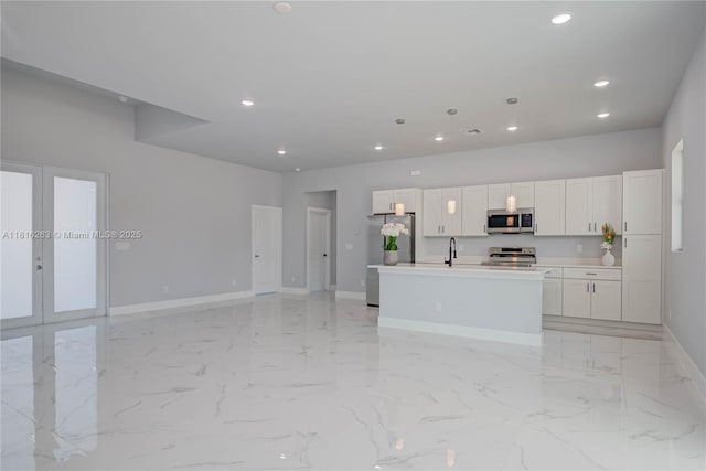 3417 71st St W, Lehigh Acres, FL 33971 - kitchen featuring stainless steel appliances, baseboards, french doors, recessed lighting, and a kitchen island with sink