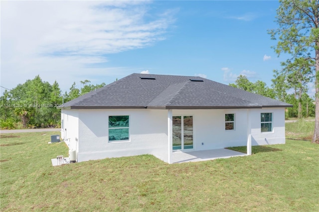 3417 71st St W, Lehigh Acres, FL 33971 - rear view of property featuring a shingled roof, a yard, stucco siding, and a patio area