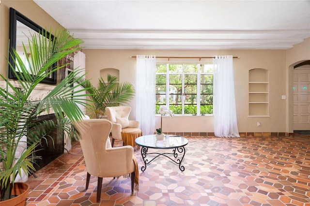 492 NE 55th St, Miami, FL 33137 - sitting room featuring built in features, arched walkways, beamed ceiling, and baseboards