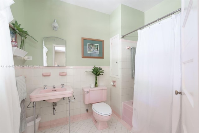 492 NE 55th St, Miami, FL 33137 - bathroom featuring toilet, tile walls, tile patterned floors, shower / bathtub combination with curtain, and wainscoting