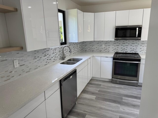 2160 NW 30th St, Miami, FL 33142 - kitchen with appliances with stainless steel finishes, white cabinets, modern cabinets, decorative backsplash, and open shelves