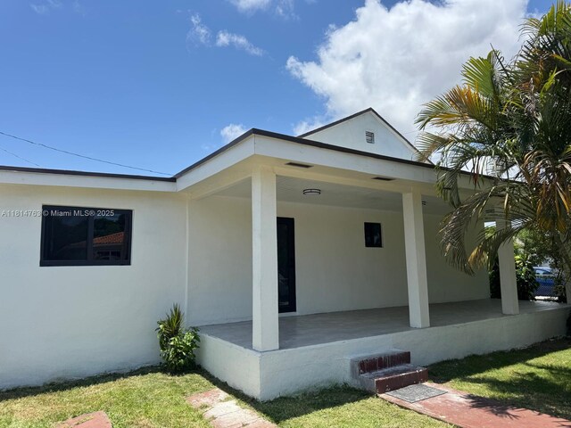 2160 NW 30th St, Miami, FL 33142 - doorway to property featuring stucco siding and a porch