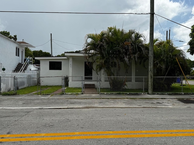 2160 NW 30th St, Miami, FL 33142 - view of front facade with stucco siding, a fenced front yard, and a gate