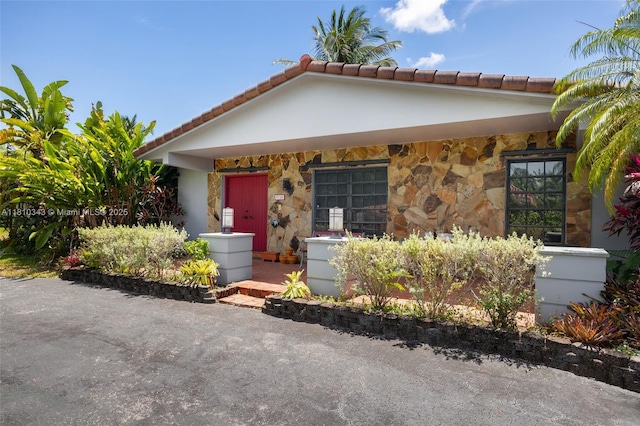9728 SW 135th Ter, Miami, FL 33176 - view of front of home featuring stone siding and a tiled roof