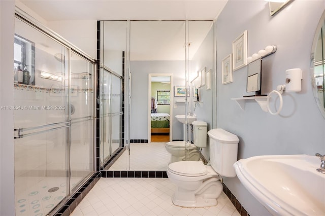 9728 SW 135th Ter, Miami, FL 33176 - ensuite bathroom featuring a sink, tile patterned floors, toilet, a stall shower, and baseboards