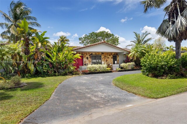 9728 SW 135th Ter, Miami, FL 33176 - view of front facade with a front lawn, stone siding, asphalt driveway, a tiled roof, and stucco siding