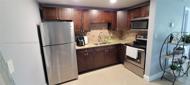 5773 Washington St Unit J2, Hollywood, FL 33023 - kitchen featuring appliances with stainless steel finishes, a sink, tasteful backsplash, light stone counters, and light tile patterned flooring