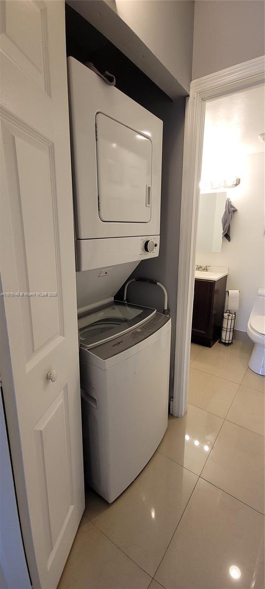 5773 Washington St Unit J2, Hollywood, FL 33023 - laundry room with stacked washer / dryer and light tile patterned flooring