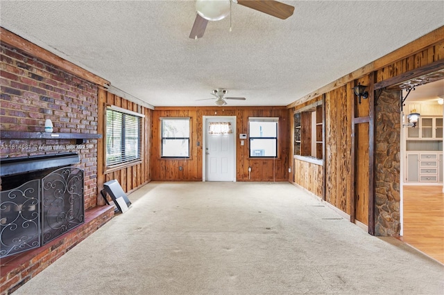 4878 NW 2nd Ct, Plantation, FL 33317 - unfurnished living room featuring ceiling fan, a textured ceiling, wood walls, carpet flooring, and a fireplace