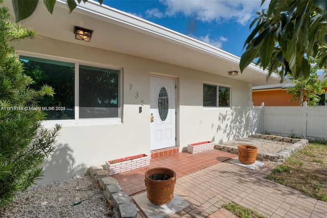 735 NE 38th St, Oakland Park, FL 33334 - doorway to property with stucco siding and a patio area